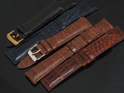 trois couleurs différentes de bracelets de montre en cuir d'alligator sur un fond noir