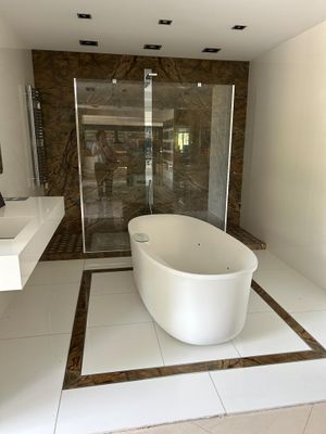 a large white bath tub sitting in a bathroom next to a walk in shower