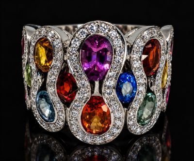 a close up of a ring with multi colored stones on a black surface