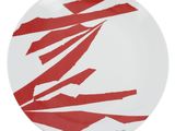 une assiette rouge et blanche sur laquelle sont posés des morceaux de papier déchirés