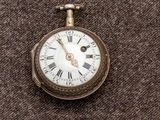 une montre de poche en argent avec des chiffres romains