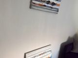 a picture of a living room with a couch and a painting on the wall