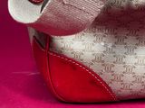 a close up of a purse on a pink surface