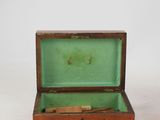 a small wooden box with a green lid on a white surface