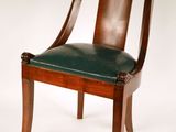 une chaise en bois avec une assise en cuir vert sur fond blanc