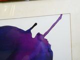 une photo d'une photo d'une pomme violette accrochée au mur