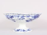 a blue and white bowl sitting on a white pedestal