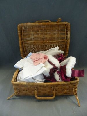 un panier en osier contenant des vêtements et un ours en peluche
