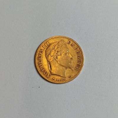 a close up of a gold coin on a white surface