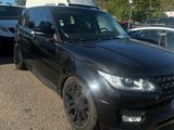 the black range rover is parked in a parking lot with other cars