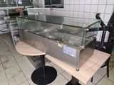 un plan de travail surmonté d'une vitrine, dans une cuisine