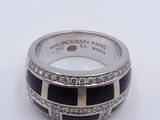 a close up of a ring on a white surface with diamonds