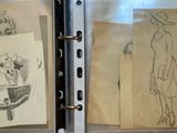 sketches of a woman in a hat and dress are displayed in a glass case