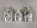 trois flacons à tabac en verre ornés de motifs d'oiseaux et de fleurs peints