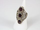 a close up of a silver ring with garnets on it