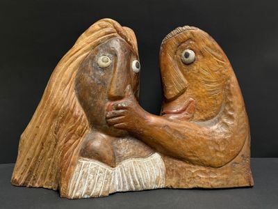 sculpture en bois représentant un couple s'enlaçant sur fond noir