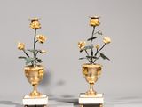une paire de vases en or ornés de roses, posés sur des socles en marbre, sur une table