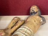 a statue of jesus laying on a wooden table