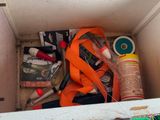 a box filled with assorted items that include scissors, tape, tape cutters, and other items