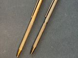 two pens and a ballpoint pen on a table
