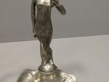 a silver figurine of a boy on a pedestal