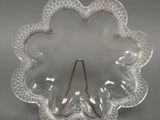 plat en verre transparent en forme de fleur, muni d'une poignée dorée sur fond gris
