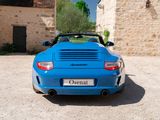 a blue sports car parked in front of a stone building