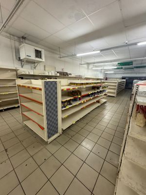 de nombreuses étagères vides au milieu d'un supermarché