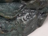 a bronze statue of a bird on a branch