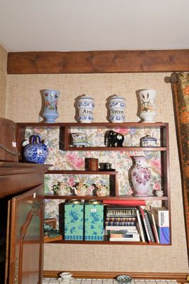 de nombreux vases et livres sur les étagères de cette pièce