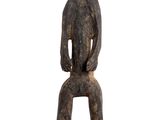 statue of a monkey sitting on a stool on a white background