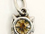 sterling silver charm with a yellow crystal stone in the center