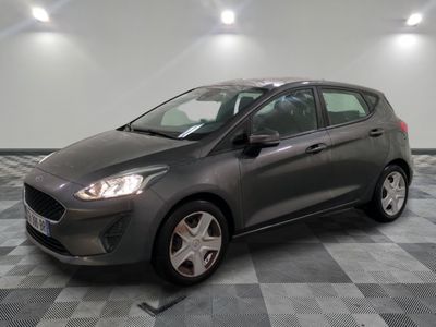 une Ford Fiesta grise garée sur un sol à damier dans un garage