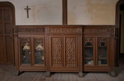 une grande armoire en bois surmontée d'une croix