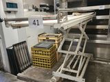 une photo d'un tapis roulant dans un entrepôt, sur lequel se trouvent des caisses de denrées alimentaires