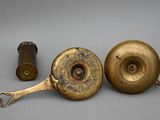 two old brass objects are sitting on a gray surface