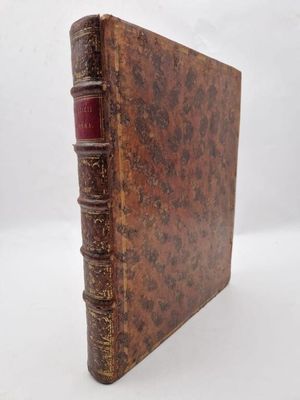 an old book sitting on top of a white surface