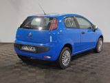 the small blue car is parked on a checkered tile floor
