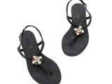 une paire de sandales noires ornées de perles sur les orteils