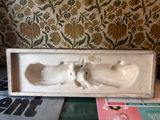 a small statue of a cat in a box on a table