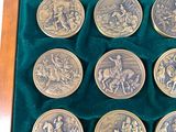 six silver coins in a wooden box with velvet lining