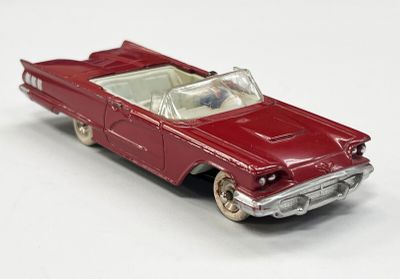 une petite voiture rouge posée sur une surface blanche