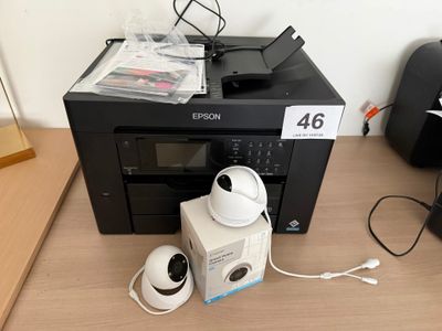 une photo représentant une imprimante et d'autres appareils électroniques posés sur un bureau