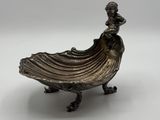 un plateau en argent sur lequel est assise une femme