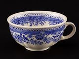a blue and white cup on a black table