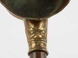 an image of a brass vase with a wooden handle and a metal lid