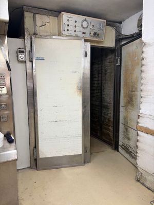 a door in the middle of a dirty kitchen