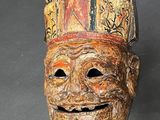 an image of a wooden mask with a face painted on it