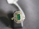 a close up of a ring with a green stone in it