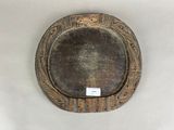 une assiette marron posée sur une table blanche, sur laquelle est apposée une étiquette